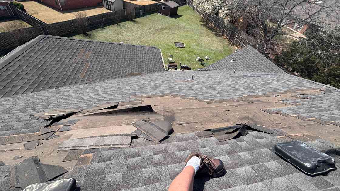 what wind damage looks like on a roof photo showing what wind damage looks like on a roof and of missing and lifted shingles on residential roof in Oklahoma City after storm