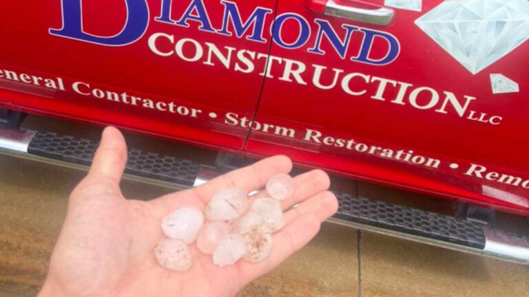 hand holding hail once homeowner called in storm damage claim to carrier