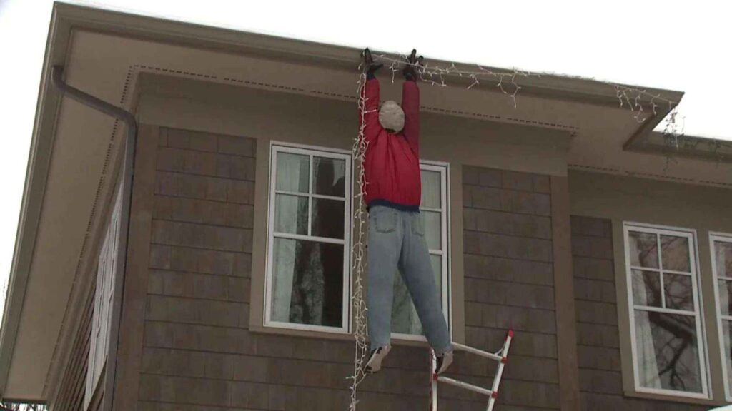 man hanging from roof gutters after not following roof safety tips