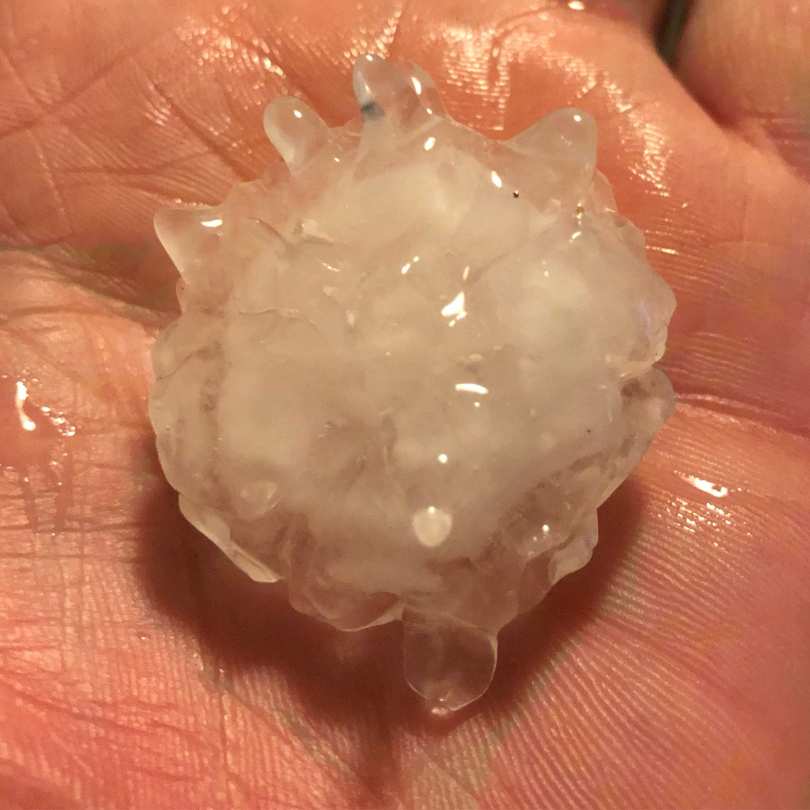 hand holding two inch hail stone that fell in Shawnee, OK on April 19, 2023 during massive hail storm