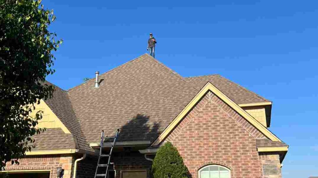 roofer standing on top of residential home in Oklahoma City ready to make repairs after hail storm