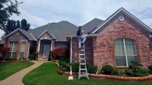 roofer climbing on ladder to perform roof inspection to find out how long does hail damage take to cause roof leaks