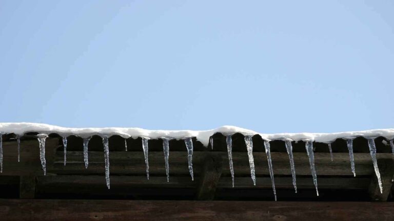 ice buildup along roof causing winter gutter damage to residential home