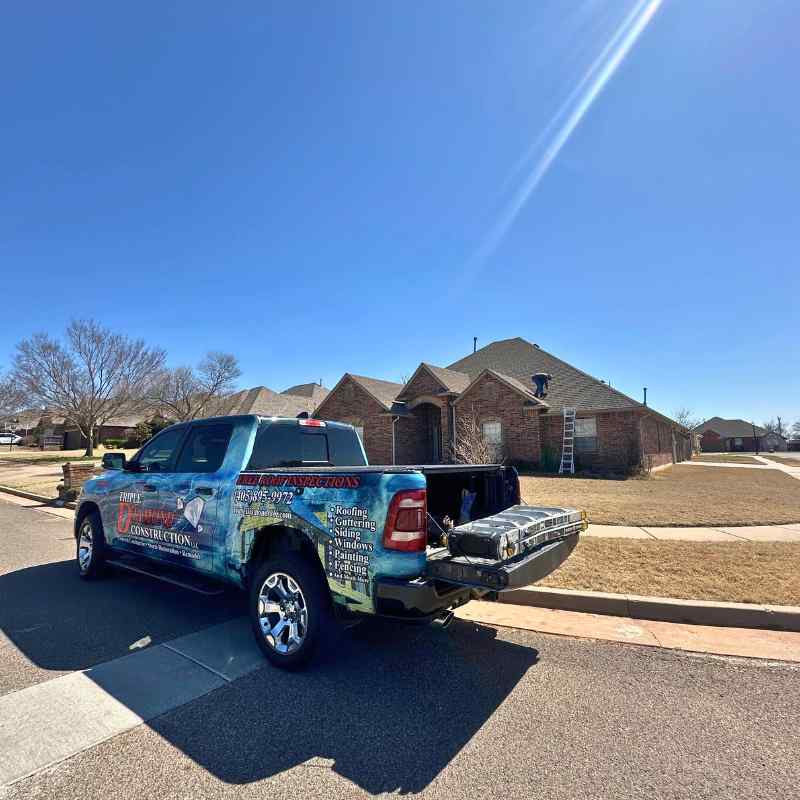 roofing company truck outside of residential home in Oklahoma City with roofer walking up to door to give a free roof inspection