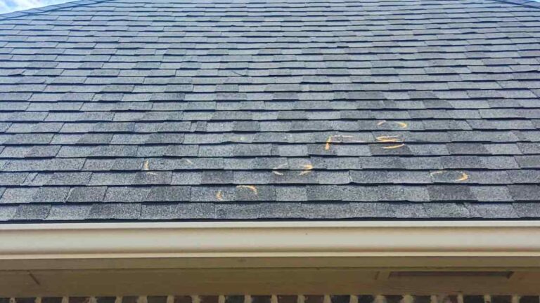 close up of roof inspection and gutters with hail damage found by using summer roof maintenance checklist for OKC homeowners