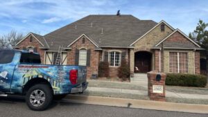 roofer on residential home investigating roof leak causes