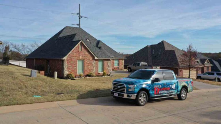 roofing company outside of residential home in Oklahoma City after a storm explaining roofs lifespan after a hailstorm to homeowner