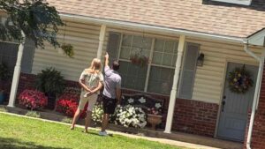 Triple Diamond Construction giving a roof inspection in Moore with homeowner outside