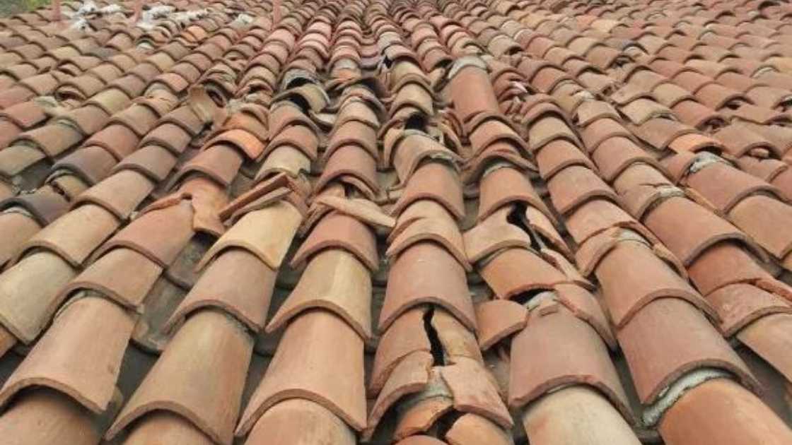 fractured and split clay tiles on roof after hail storm