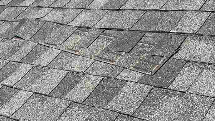 close up of damage on roof showing homeowners when to schedule a roof inspection to prevent repairs