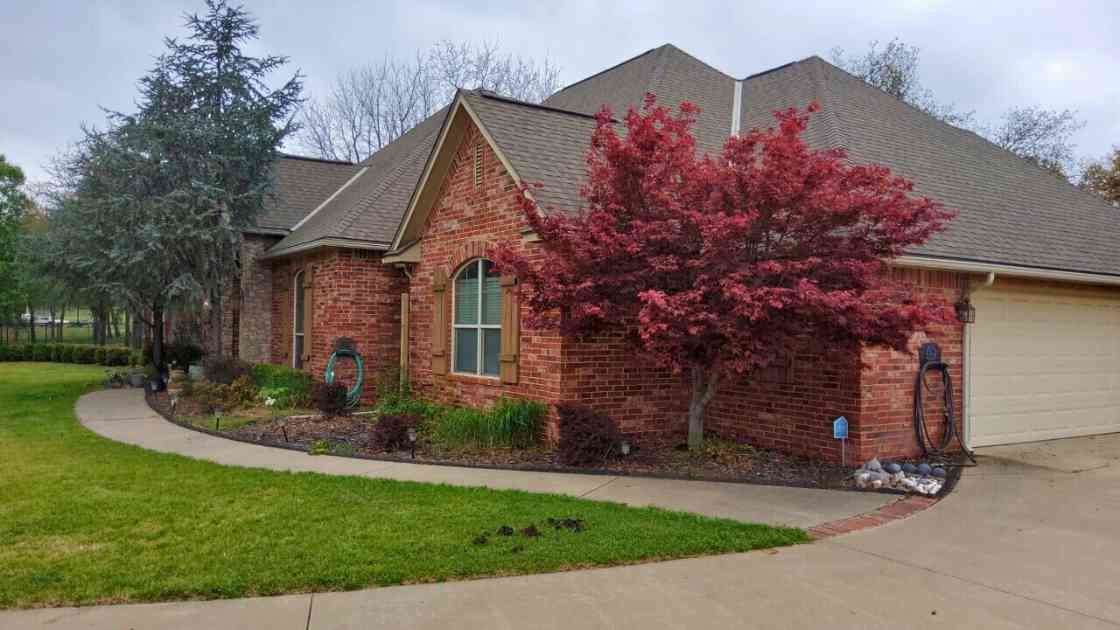 front view of residential home with hail damage before storm damage repairs in Choctaw were completed