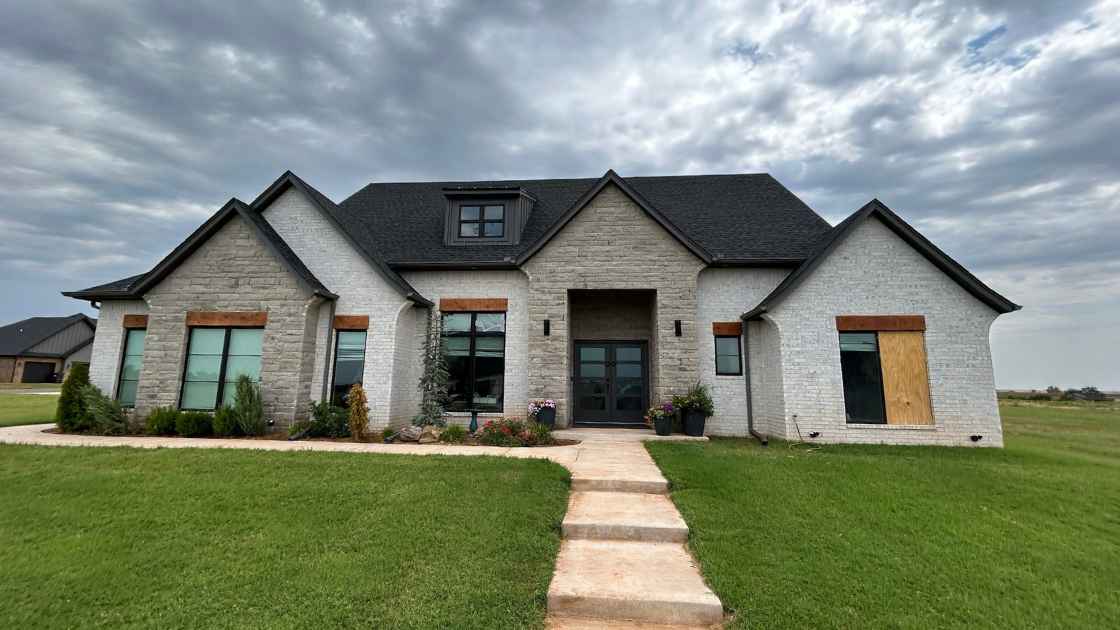 photo of residential home with broken window and hail damage roof before storm damage repairs in Guthrie, OK