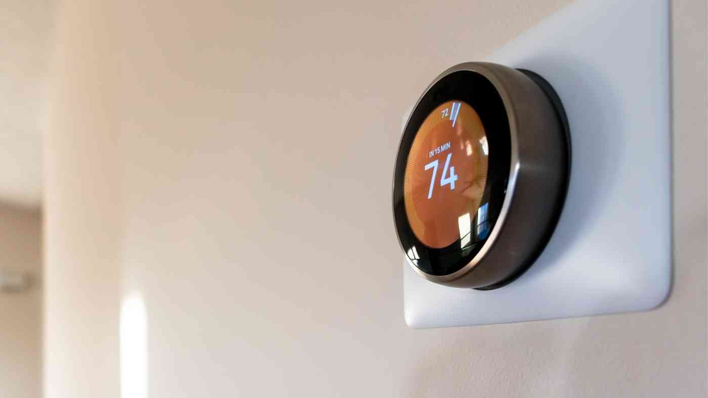 home thermostat running high from roof problems and sign to call a roofing company