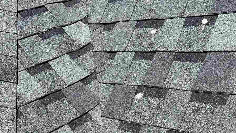 residential roof with three tab shingles with damage circled showing how hail damage can cause roof leaks