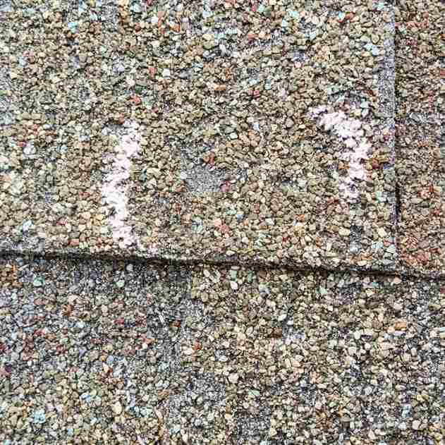 circle dent in shingle from hail damage found during roof inspection on residential home in Choctaw, OK