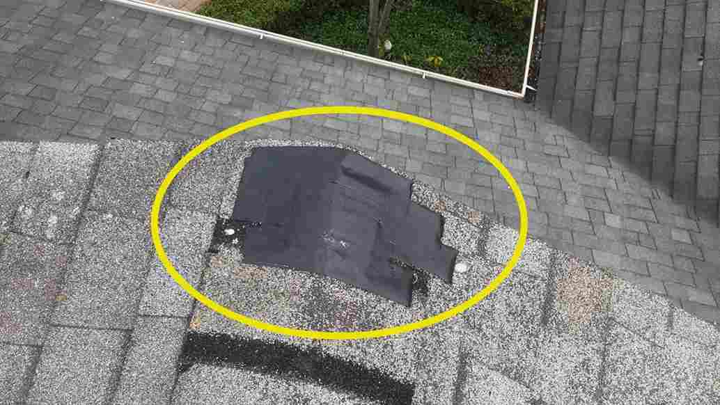 aerial view of diy roof repair on ridge using duct tape to cover damage