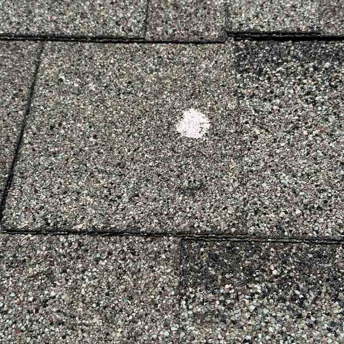 close up of hail image mark on grey asphalt shingle on residential roof in Shawnee, OK after 9/3/2023 hail storm