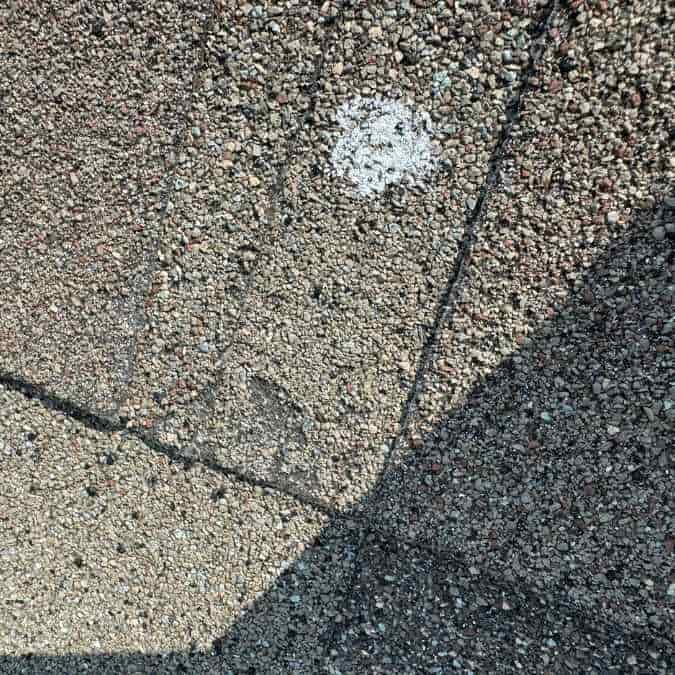 hail impact mark showing old storm damage found on residential roof in Moore, OK