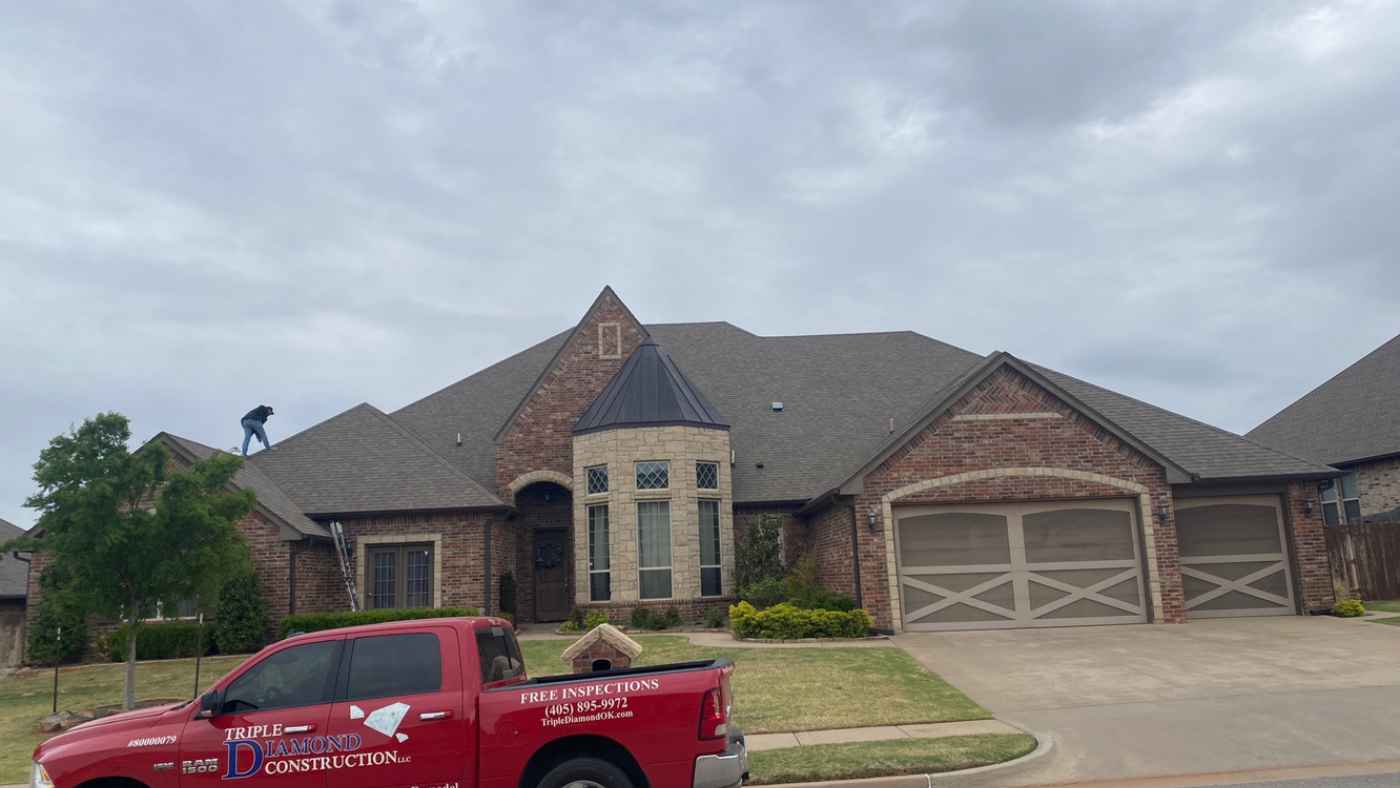 roofer on residential home after hail storm to assess storm damage and repairs in Edmond, OK