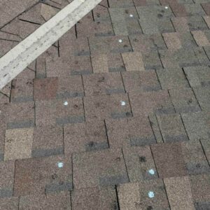 asphalt roof with dents caused by hailstorm in Edmond, OK