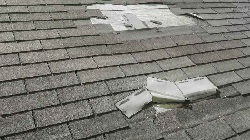 residential roof in Oklahoma City with several blow off and missing shingles leading to top roof leak causes