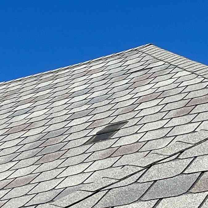 side of residential home showing missing shingles after storm in Stillwater, OK