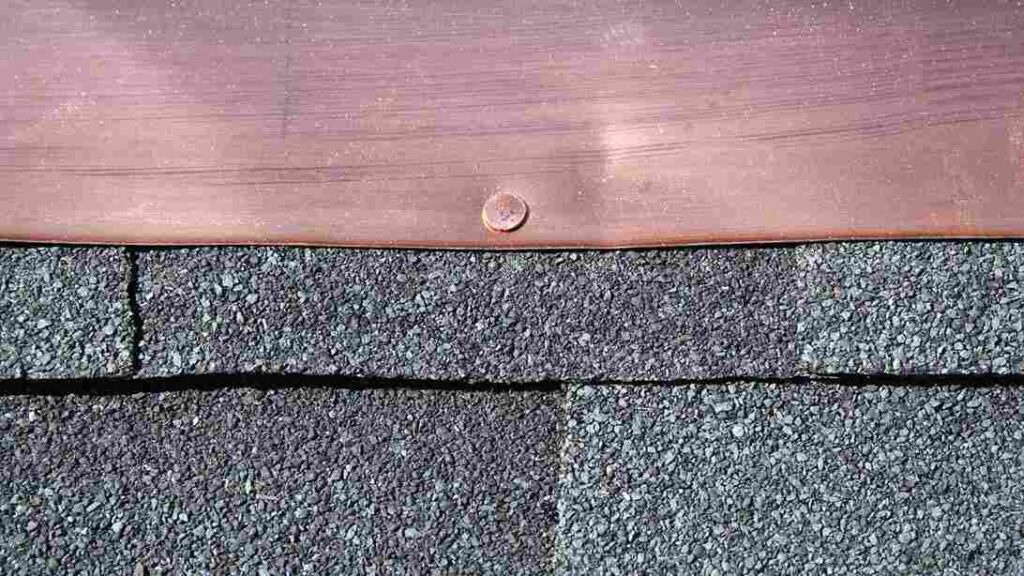 roof flashing on top of roof shingles leading to roof leak without visible signs of shingle damage
