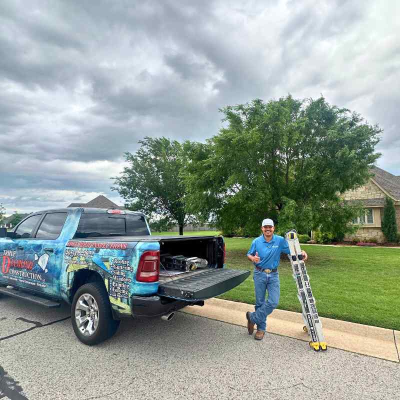 roofer standing by truck outside of a residential home in OKC after hail hailstorm to give a free roof inspection