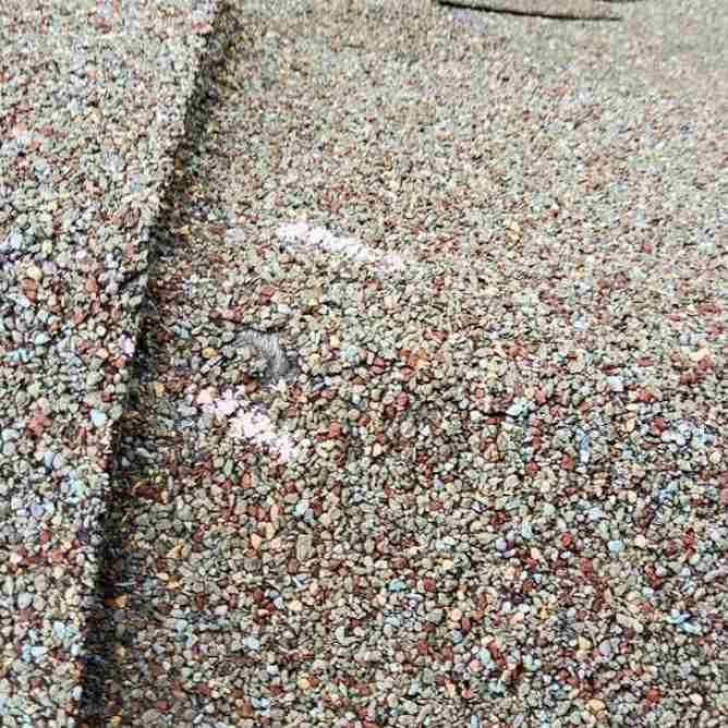 residential roof shingle showing hail impact mark after storm in Choctaw, OK