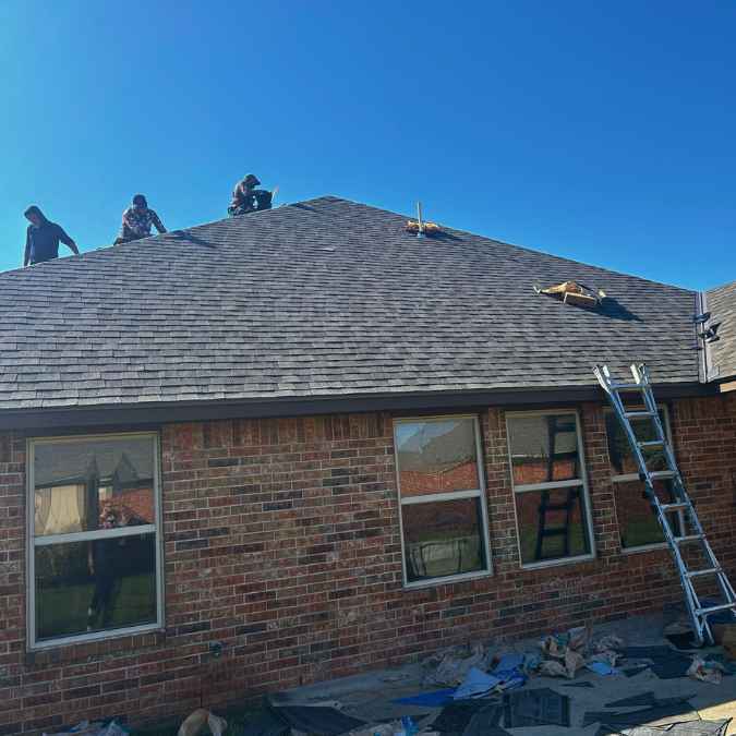 roofing crew removing old shingles and plywood to complete full roof replacement in Oklahoma City