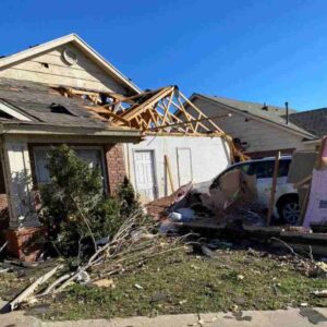 residential home with roof and siding damage from tornado in Norman, OK on Feb 26, 2023
