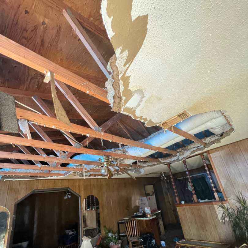 roof of home caving in after tornado damage in Idabel, OK