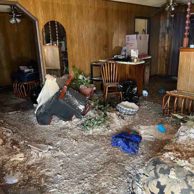 inside of home showing tornado damage repairs needed to living room and kitchen due to debris and water damage