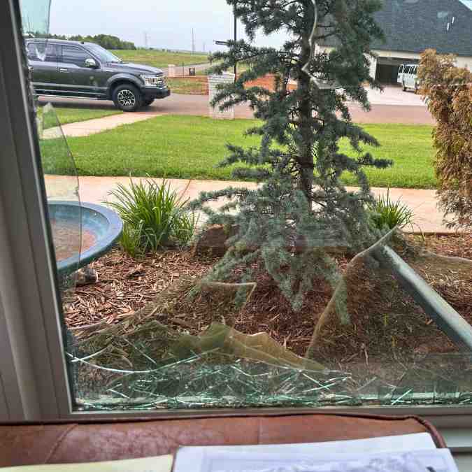 broken window after hail storm before it was tarped by general contractor